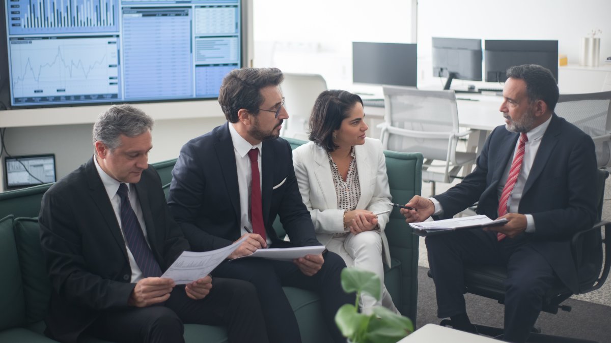 Group of business professionals discussing financial strategies in a modern office setting
